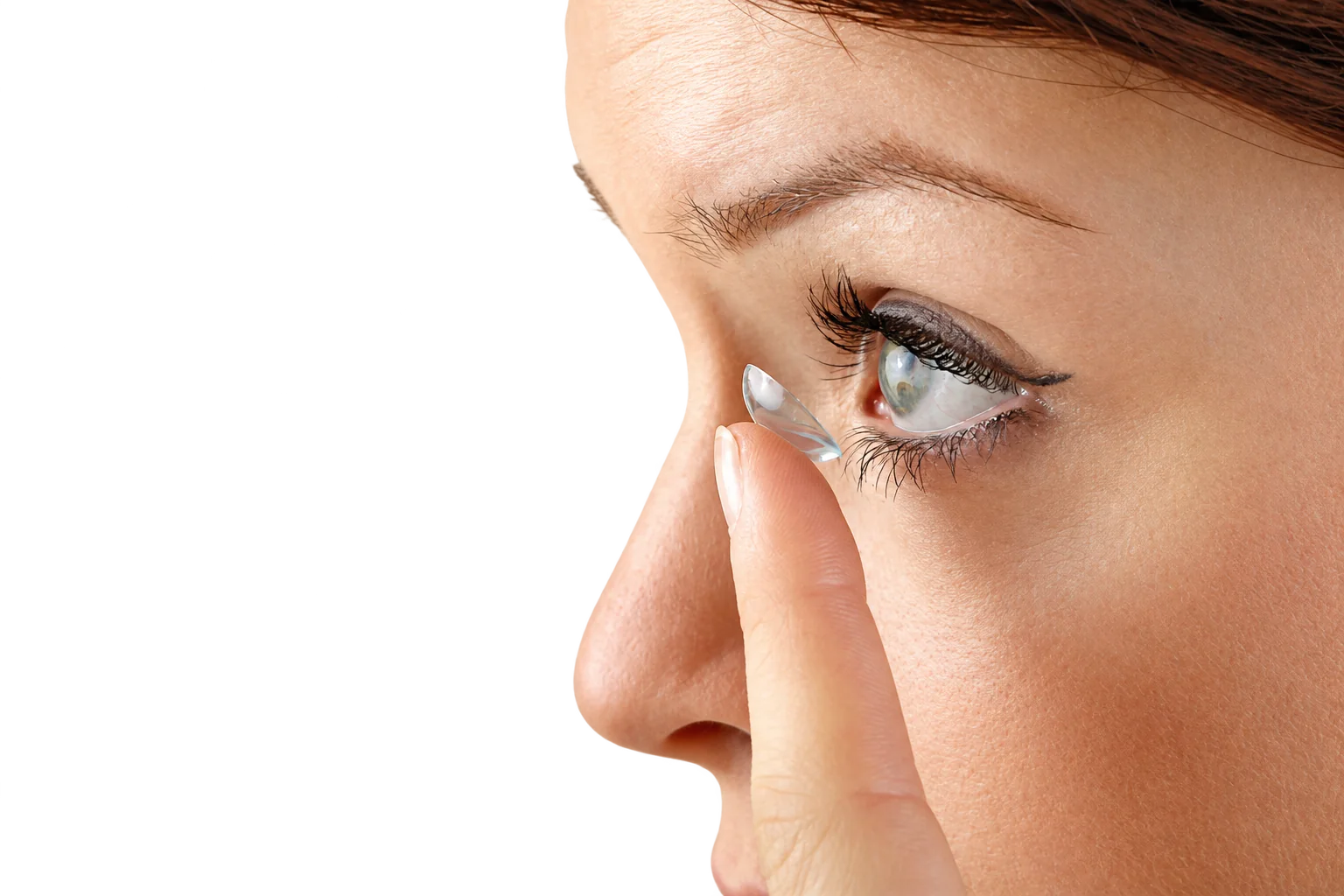 Une femme pose une lentille de contact sur son œil.