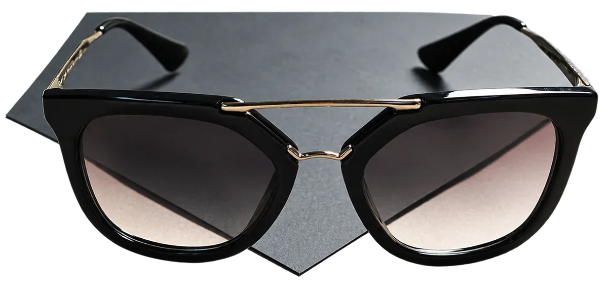Lunettes de soleil noires à double pont doré.