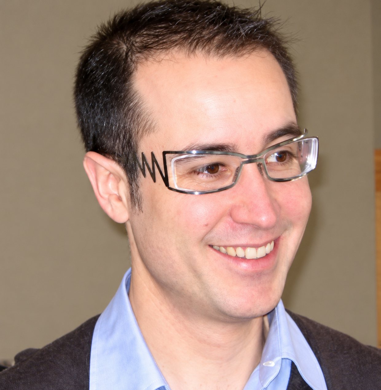 Portrait d’un homme souriant portant une monture design.